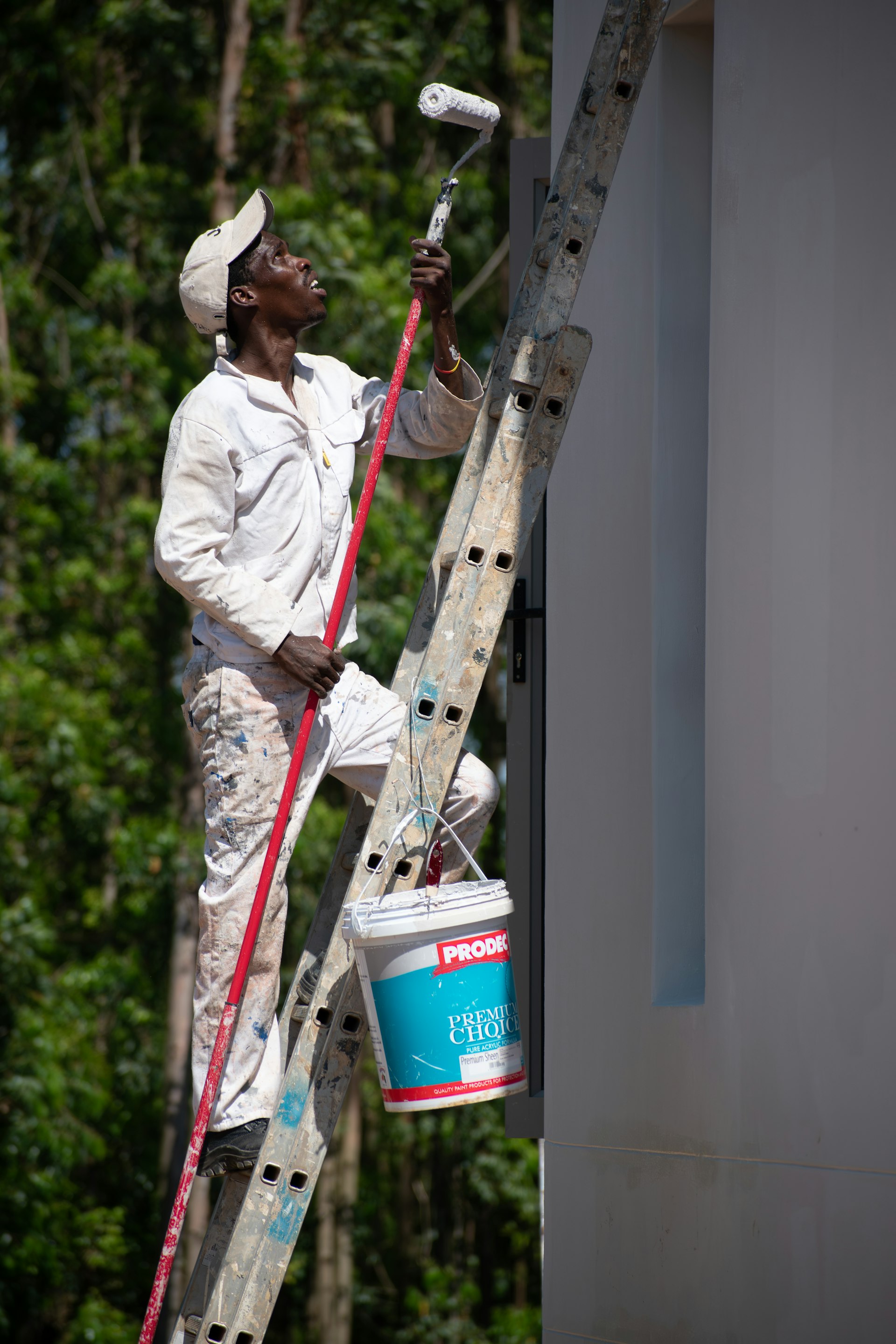 Artisan peintre façadier au travail sur un chantier de ravalement